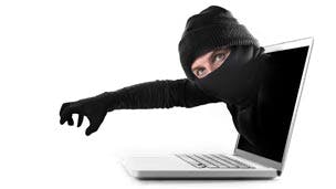 Cyber criminal emerging from a laptop