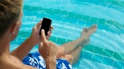 Man texting from a pool holiday