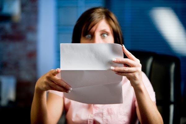 Woman looking shocked at bill