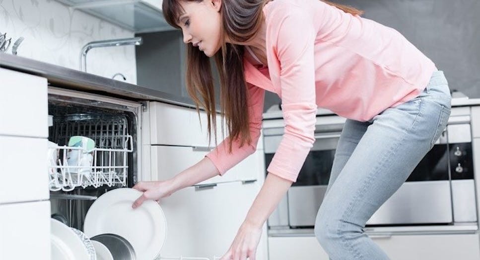 Woman using dishwasher