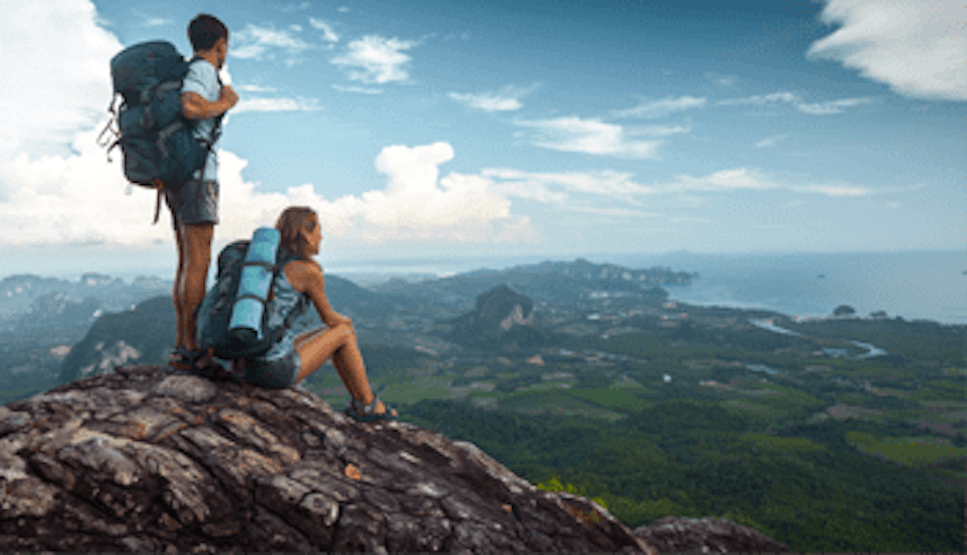 A couple of hikers on top of a mountain looking at the expansive view