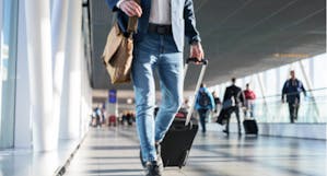 Man with luggage walking through an airport