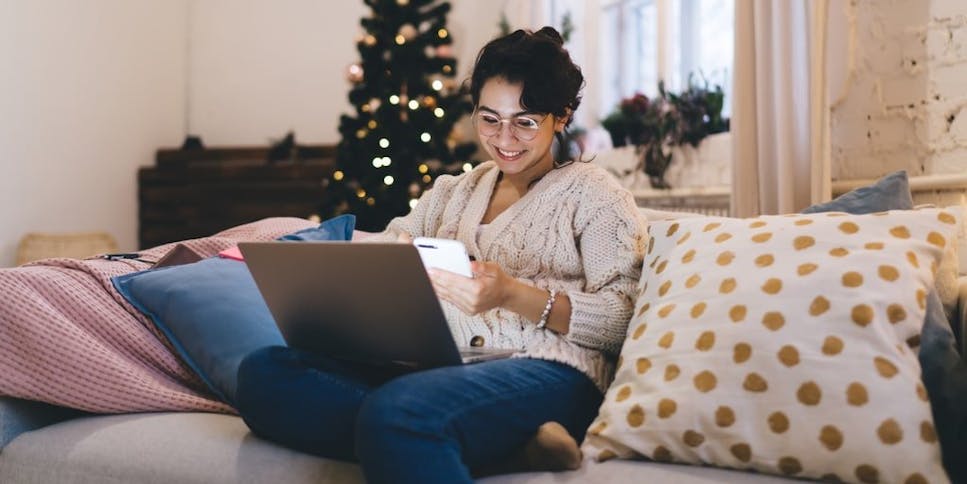 Woman on sofa at Christmas using her laptop
