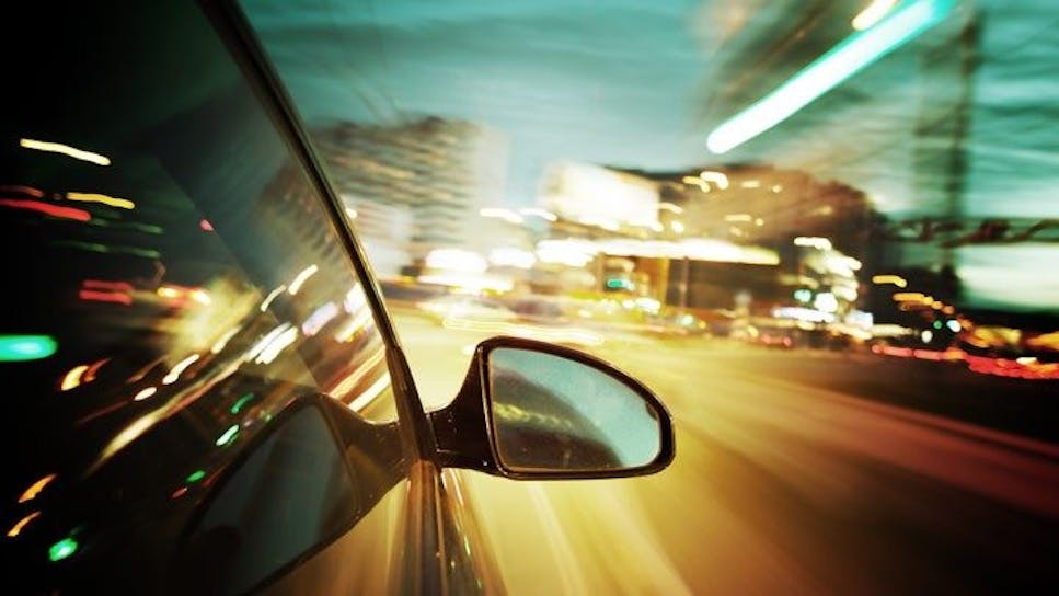 Outside of a car driving along a road at night
