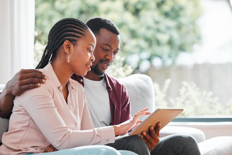 Black couple looking at a tablet
