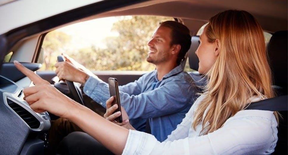 Couple talking in car with man driving