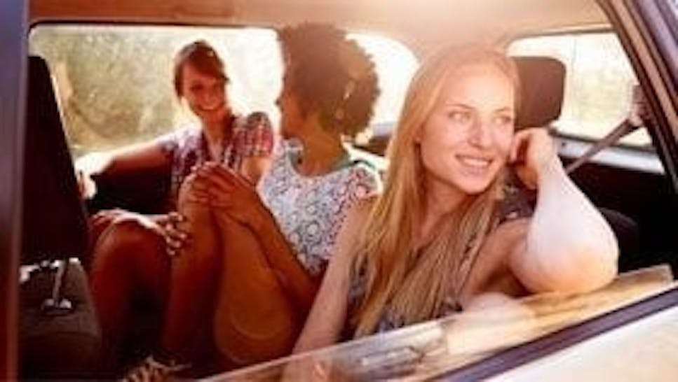 three young people travelling in a car