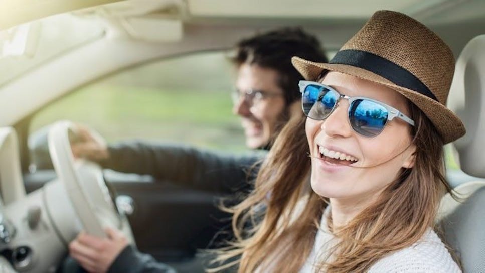 Young male and female enjoying car journey