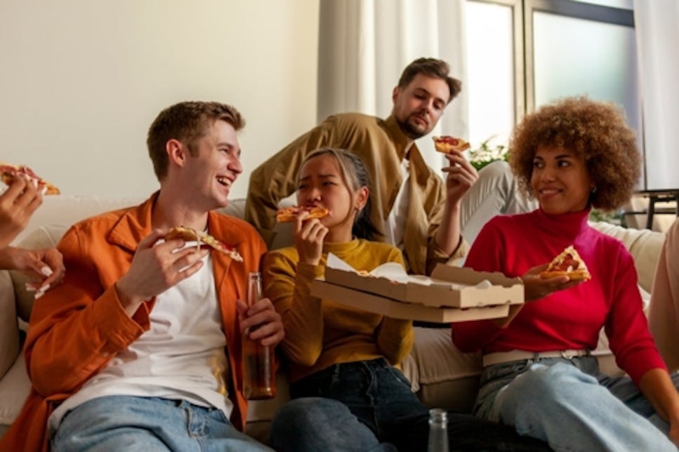Friends eating pizza at home
