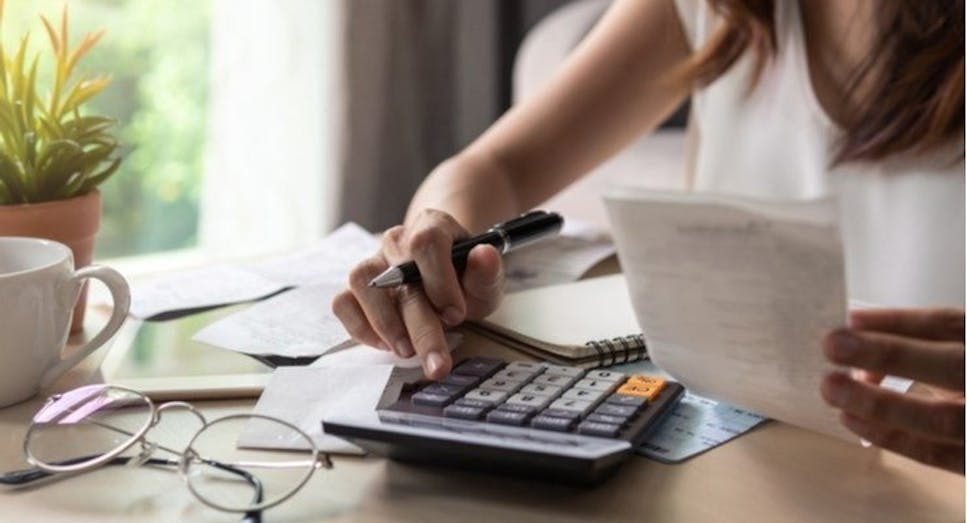 Person paying bills with a calculator