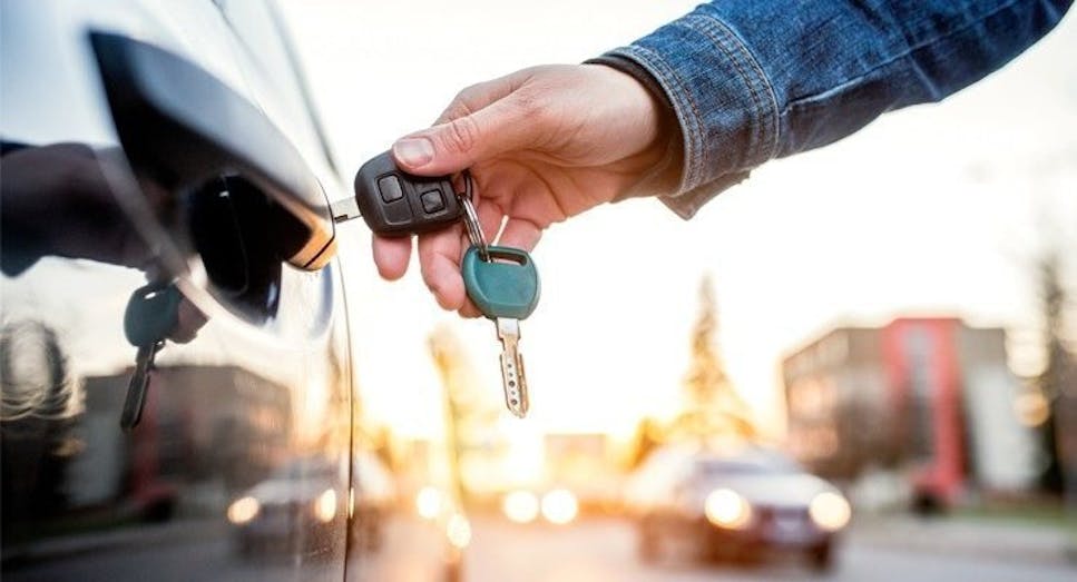 Hand putting key into car door