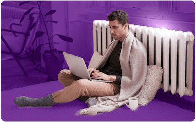 Man leaning against a radiator with a laptop