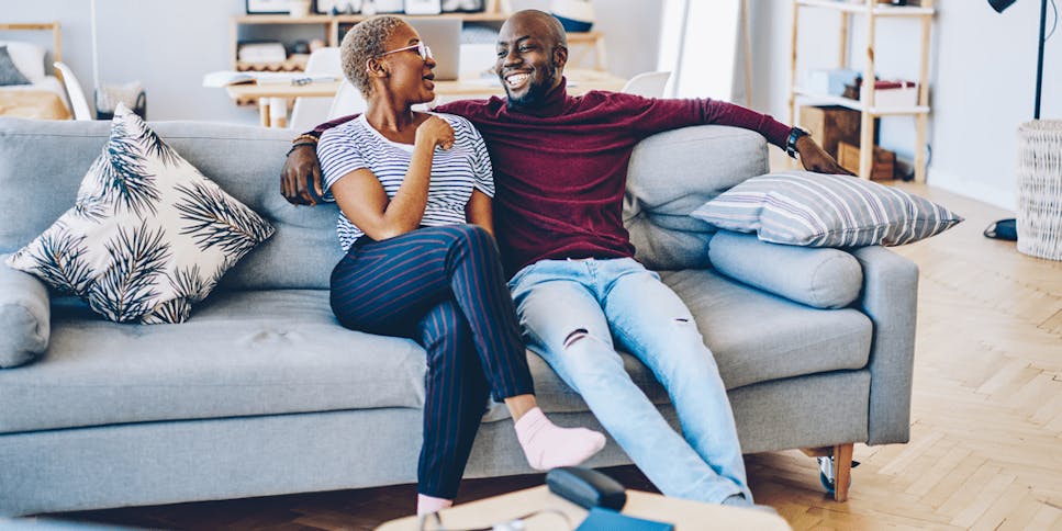 Young couple sat on the sofa in their home