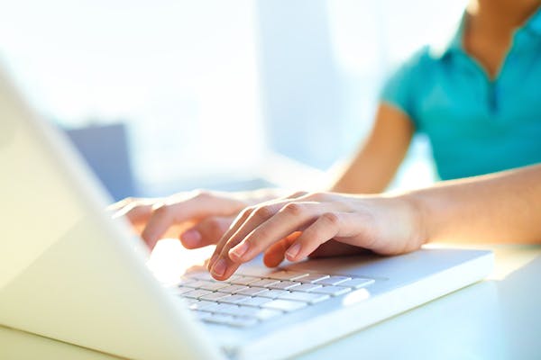 laptop in use, typing hands