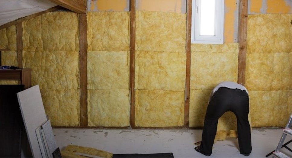 Man insulating a loft