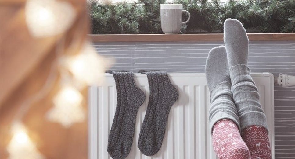 Socks hanging on radiator with person's feet up 