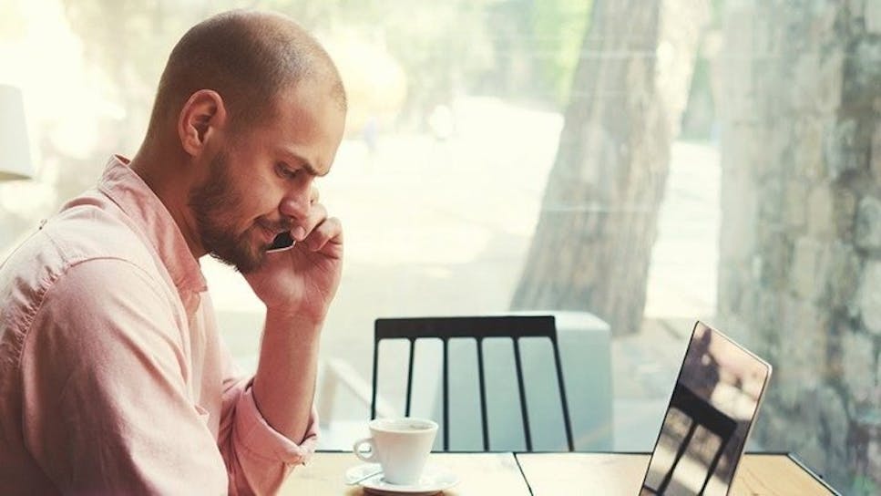 Man on telephone whilst using laptop