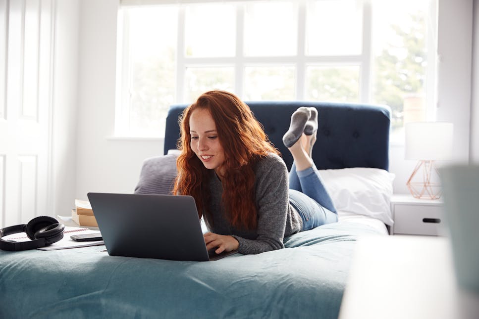 woman on laptop on bed