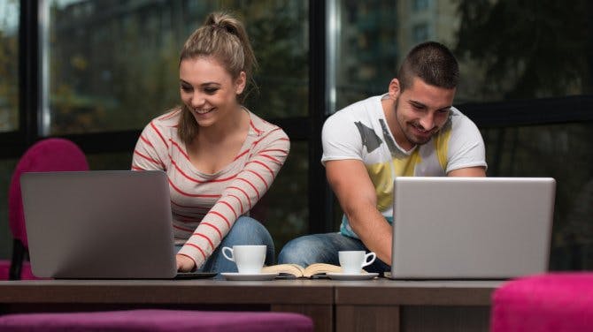 Man and woman using laptops