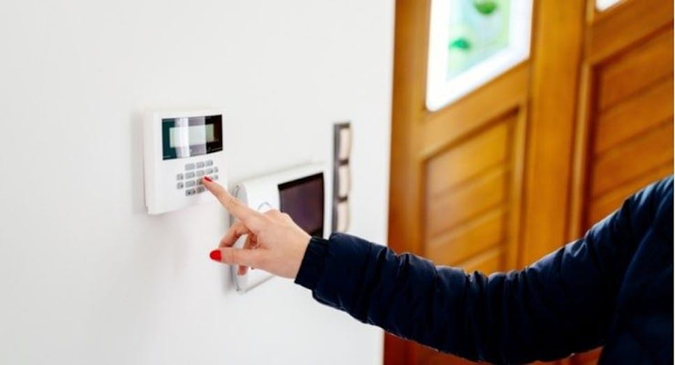 Woman setting security alarm