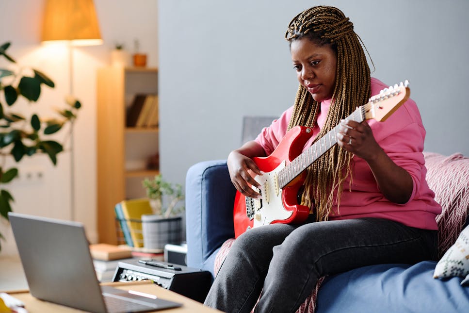 woman learning guitar at home