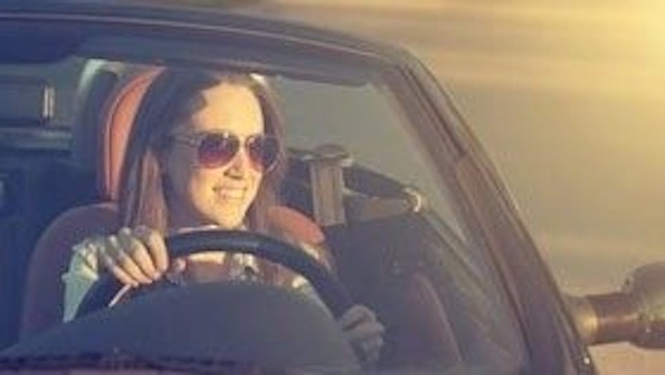 woman driving a car in the sunshine