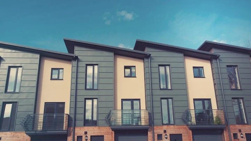 a row of black and cream attached houses with balcony