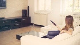Woman watching TV holding remote