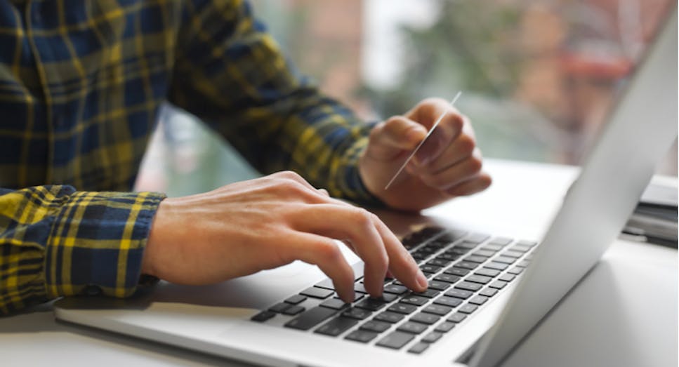 Man on laptop with debit card