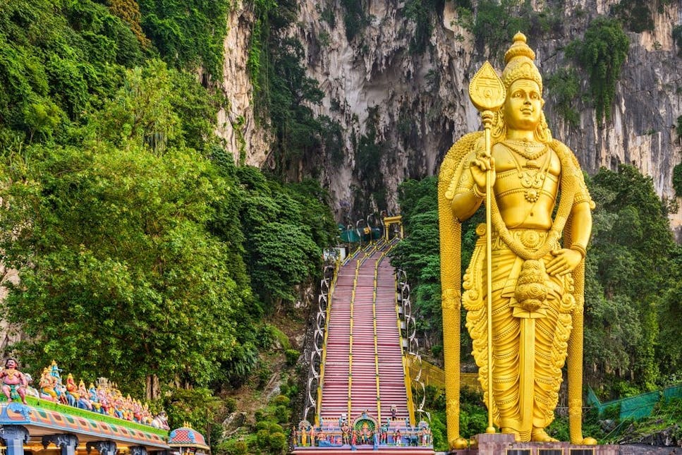 A tall gold buddha is a tourist attraction in Malaysia