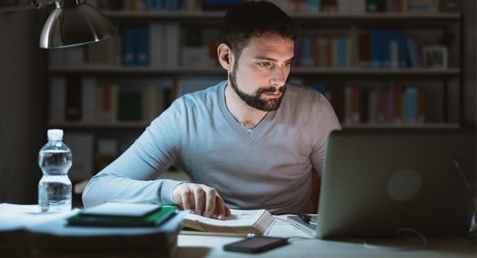 Man on laptop studying late at night