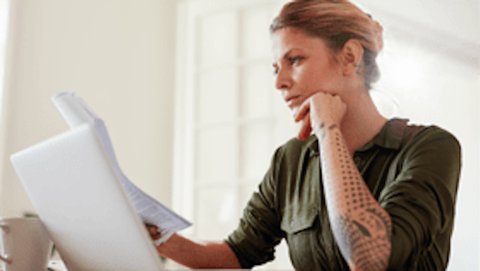 woman with laptop looking at some documents