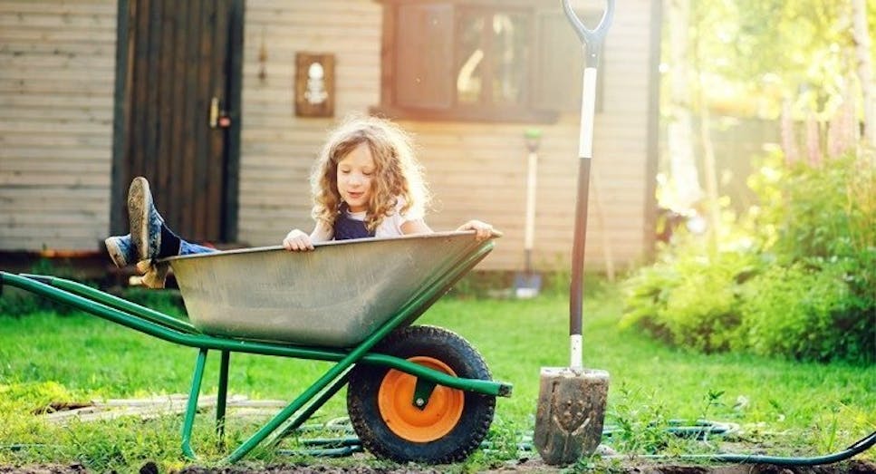 girl playing in garden, shed in background