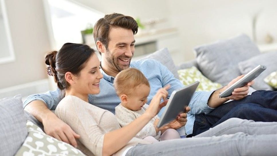 Baby playing on tablet with parents 