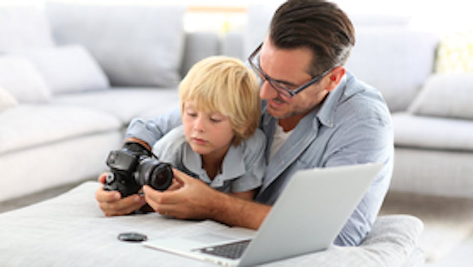 A father and son examining a DSLR camera