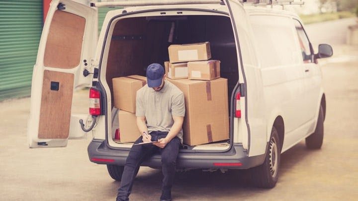 Courier sitting in the back of a van
