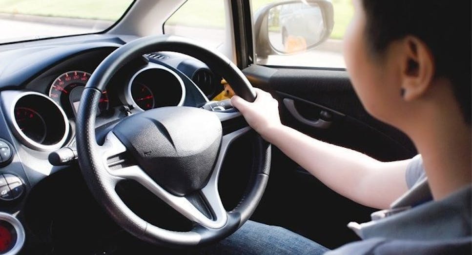 Man with hand on steering wheel