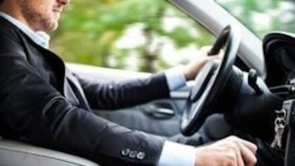 man in suit driving a car