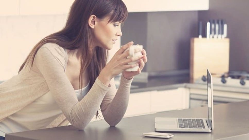 woman in kitchen looking at laptop