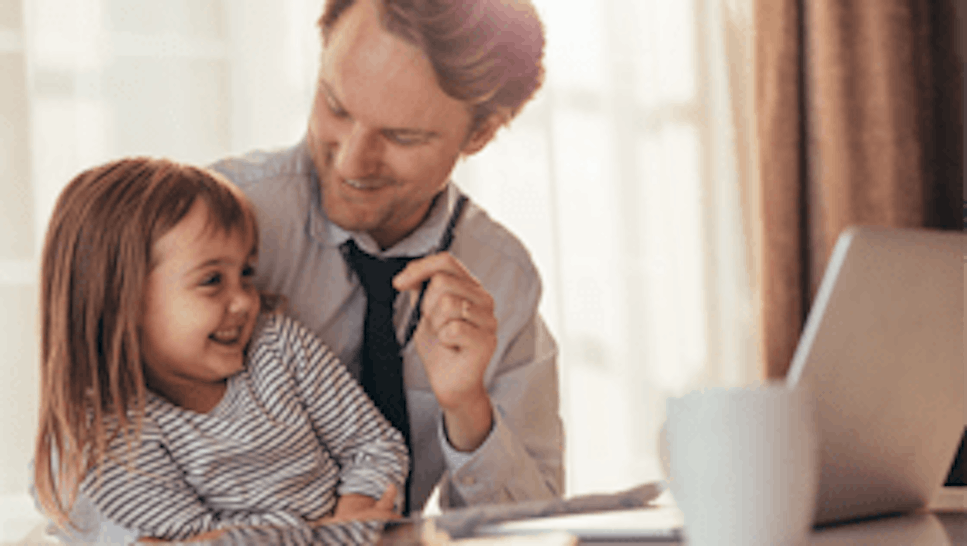 Father and daughter sitting at desk smiling