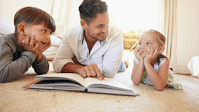 Father reading a book to his children
