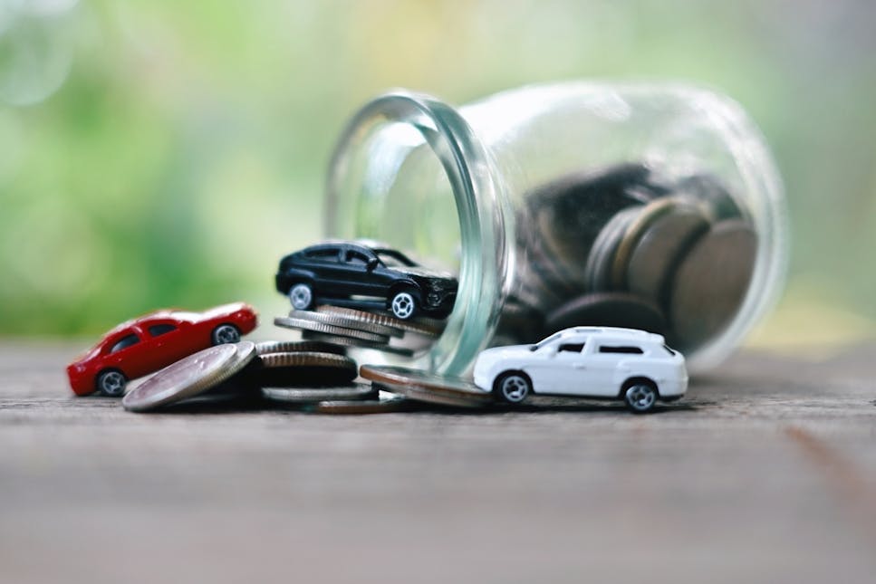 Model cars in jar of money
