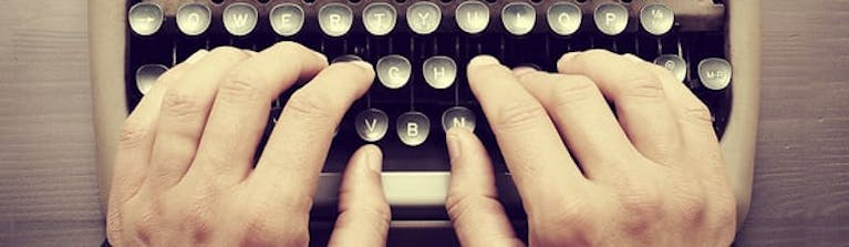 Fingers typing on a typewriter