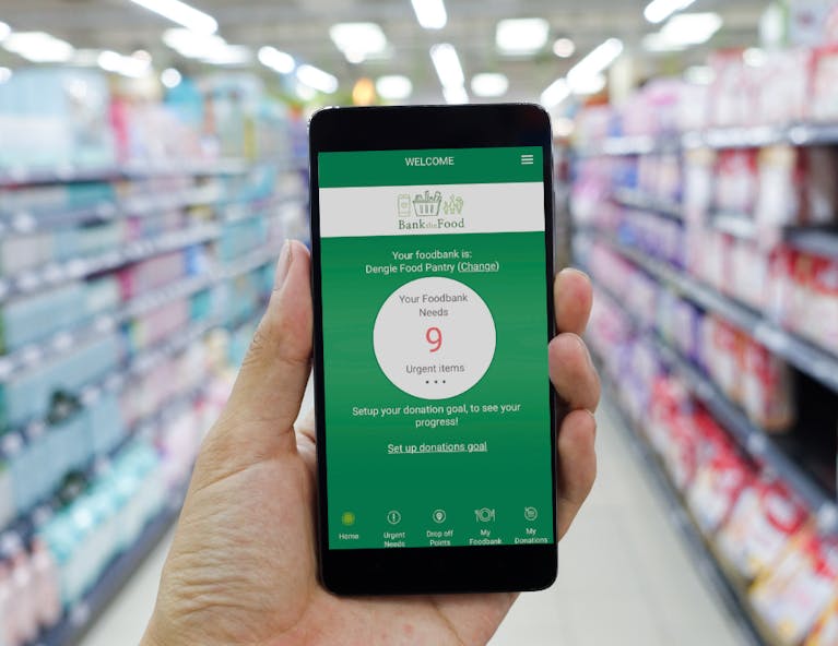 A hand holding a phone with the Bank the Food app open in a supermarket aisle.