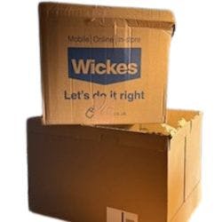 A cut out image of two large cardboard boxes that were used for houshold deliveries. one says 'Wickes' on it which is a DIY brand