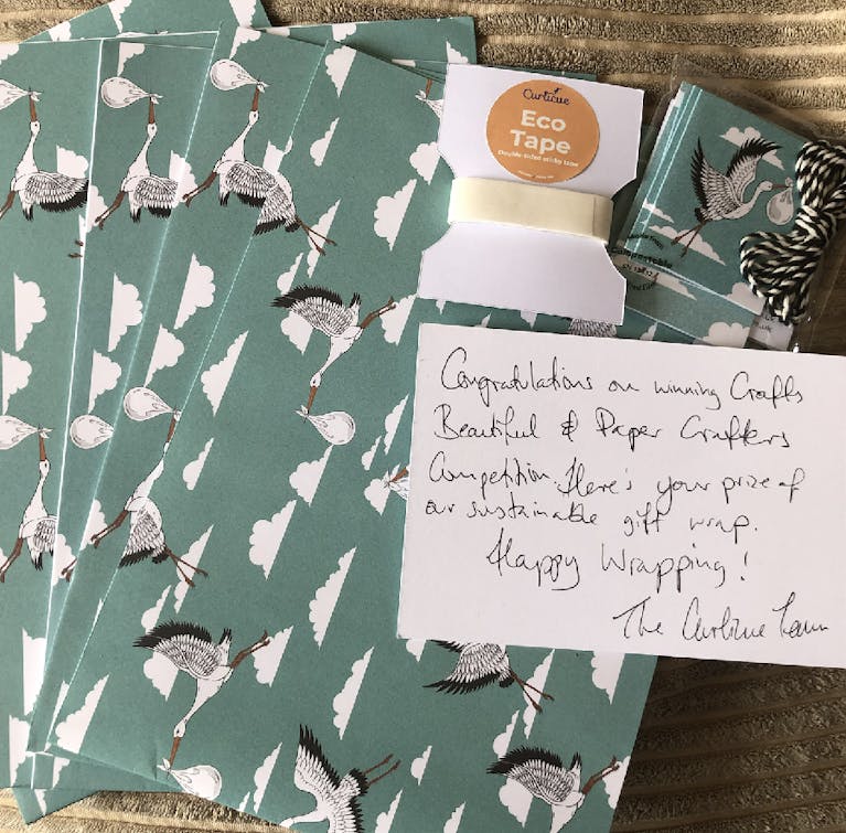 Olive green wrapping paper set decorated with images of storks