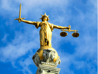 Close-up photo of the Lady Justice statue on top of the Old Bailey in London.