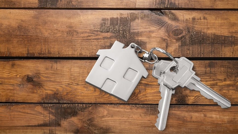 Image of keys and a house keyring on a wooden table