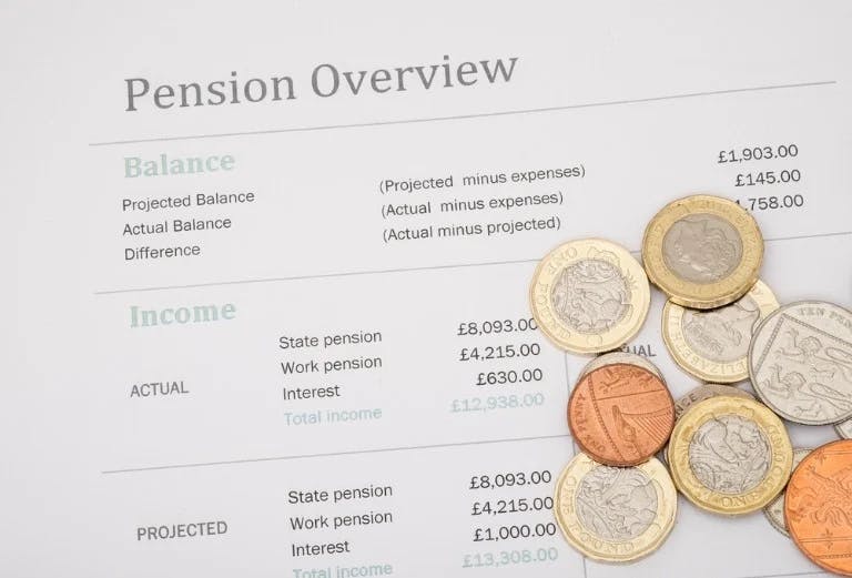 Document titled "pension overview", listing different figures, with several coins lying on top of it.