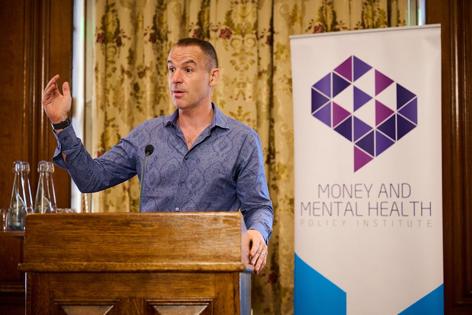 Martin Lewis standing at a lectern giving a talk on behalf of the Money and Mental Health Policy Institute.